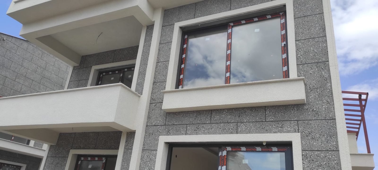 Beyaz söveli gri benekli villa cephesi